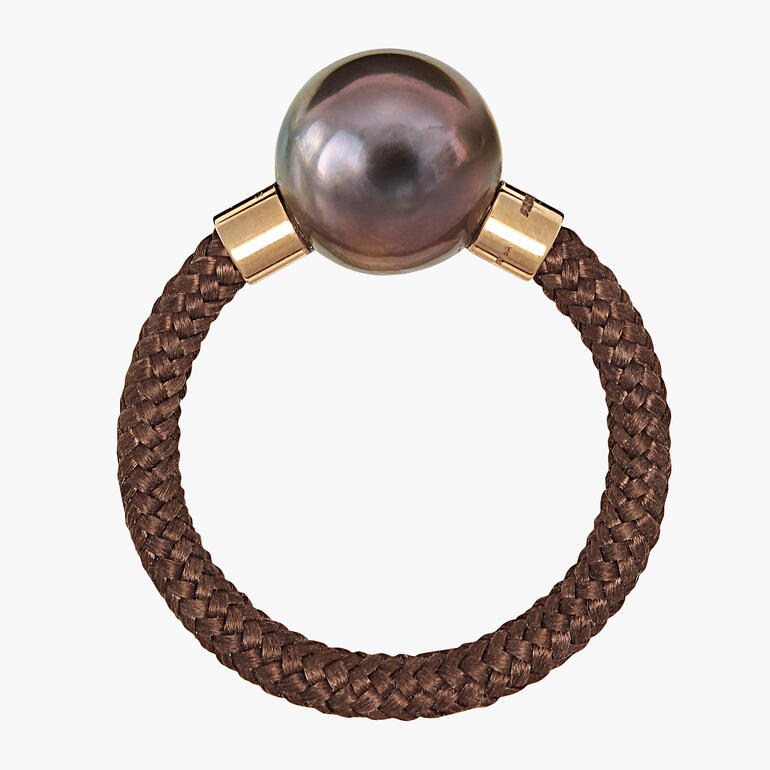 Roségoldener Ring mit schwarzer Perle auf braunem geflochtenem Band.