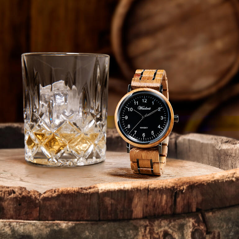 Herrenuhr aus Whiskyfässern neben einem Glas Whisky