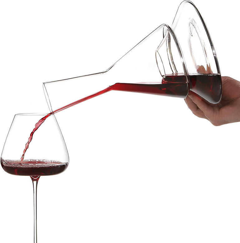 Lorsque vous versez le vin dans un verre, il est enveloppé d’air de manière intensive. Le goût et les arômes peuvent ainsi complètement se déployer. Rotwein wird aus dem Doppio Doppelstock-Dekanter in ein Glas gegossen.