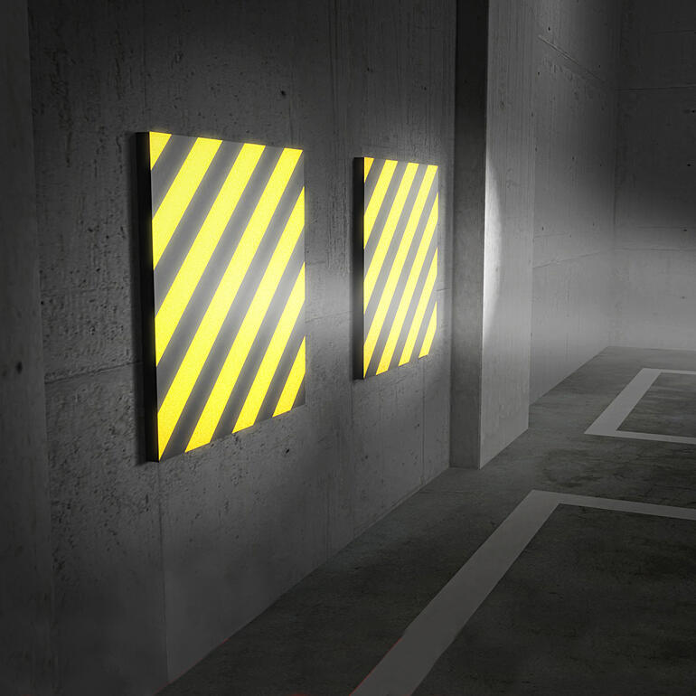 Einfallendes Licht reflektiert äusserst klar auf den gelb-schwarzen Streifen - ein deutliches Plus für mehr Sicherheit beim Einparken. Zwei Garagenwand-Polster mit gelb-schwarzen Streifen an einer Wand.