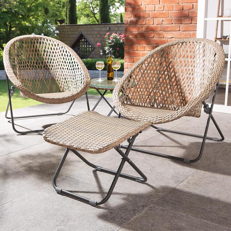 Jetzt neu: der passende Fusshocker zum Mitbestellen. Zwei faltbare Loungesessel und ein Tisch auf einer Terrasse.