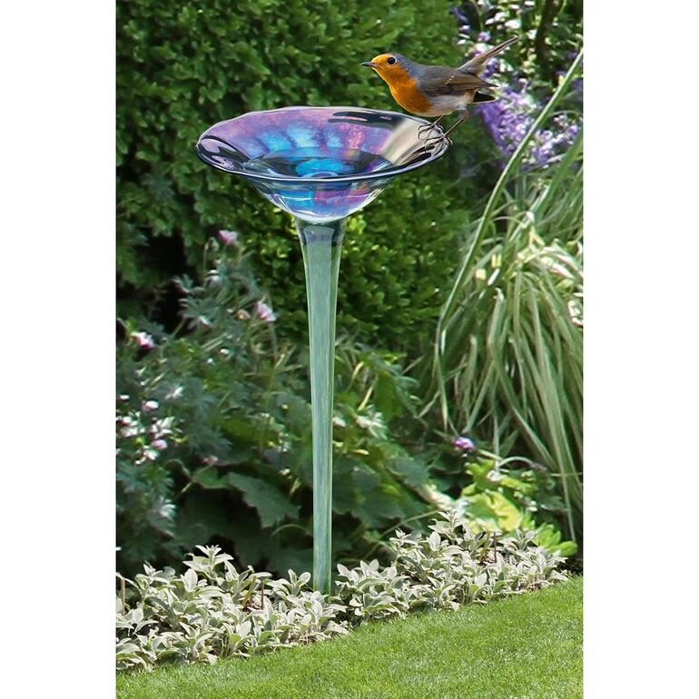 Regenbogenglas-Vogeltränke mit einem Vogel, der darauf sitzt.
