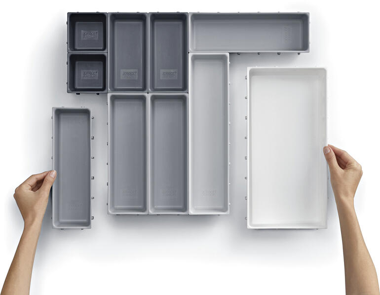 Modularer Schubladen-Organizer mit verschiedenen Einsätzen auf weißem Hintergrund.