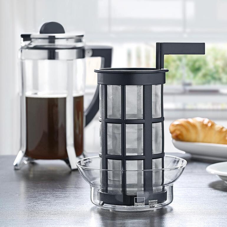 Design-Kaffeebereiter French-Pull Französische Presse und Filter auf einem Tisch mit Gebäck.