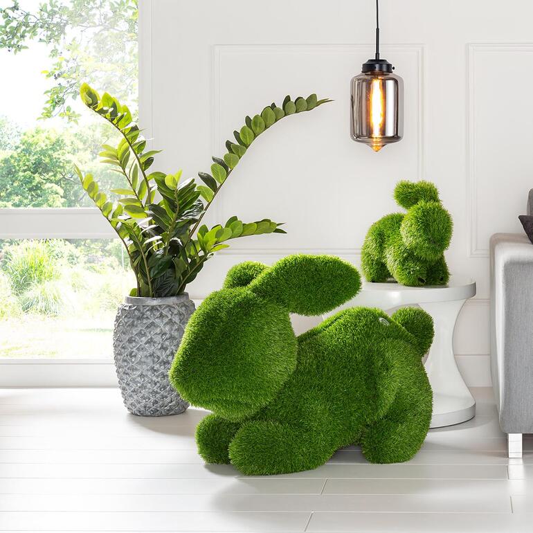 Drinnen und draussen ein hinreissender Blickfang. Gras-Hase in einem modernen Raum neben einem Pflanzengefäß.