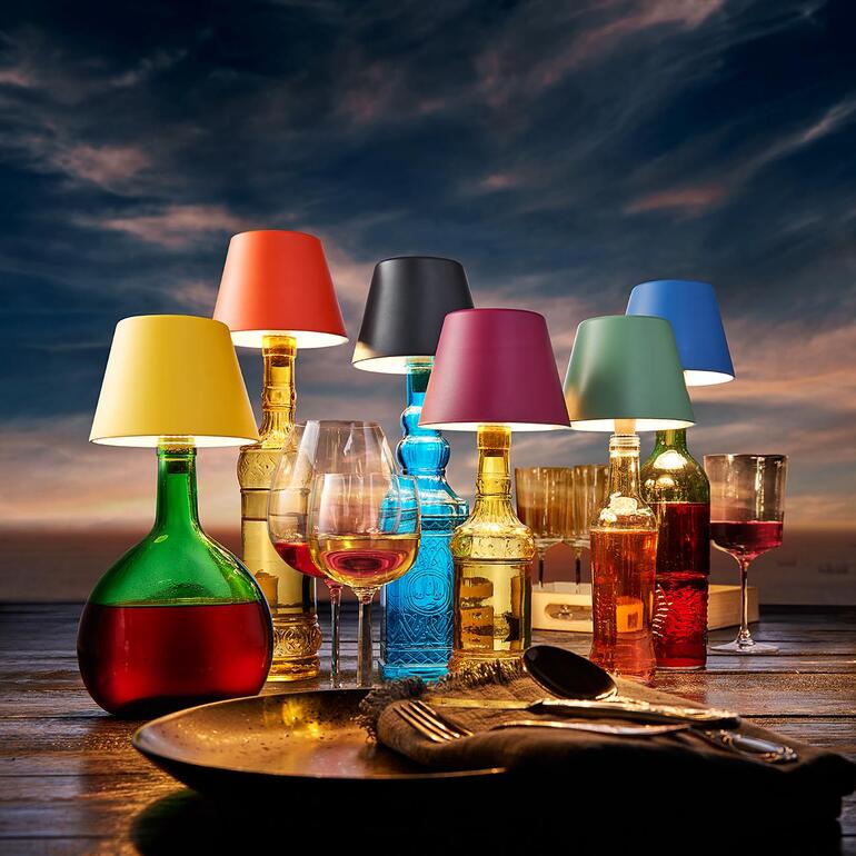 Sechs LED-Akku-Flaschenlichter in verschiedenen Farben auf einem Tisch.