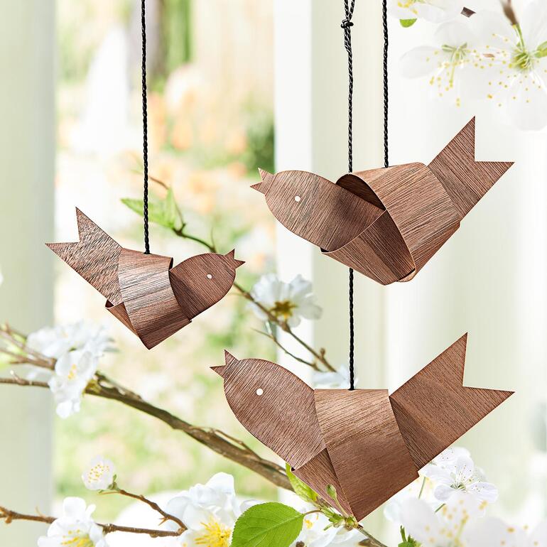 Drei hängende Knotenvögel aus Holz auf einem Ast
