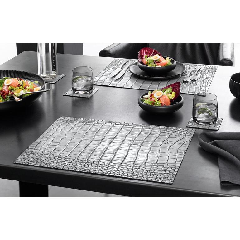 Tischset oder Glasuntersetzer in Kroko-Design auf einem gedeckten Tisch.