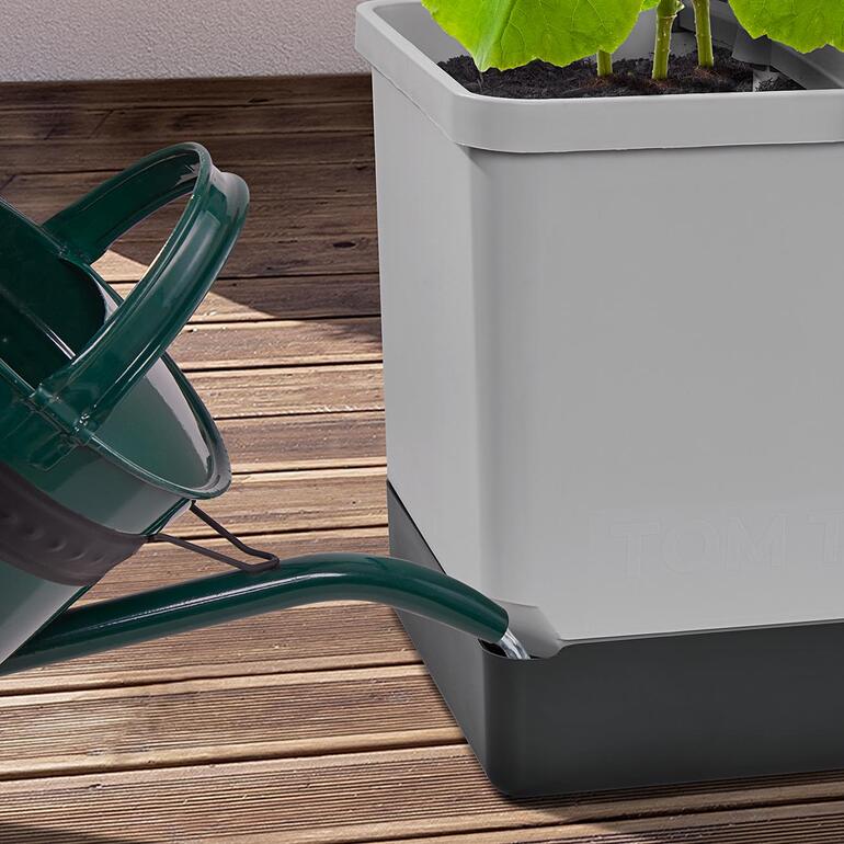 Über die seitliche Öffnung füllen Sie ganz bequem mit Kanne oder Schlauch den Wasserspeicher auf. Gießkanne gießt Wasser in den Pflanzturm