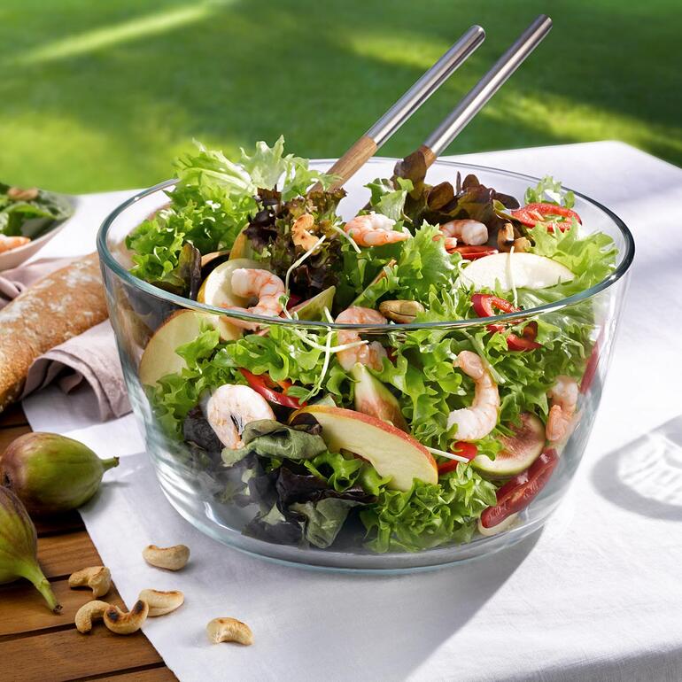 Schüssel mit frischem Salat auf einem Tisch im Freien.