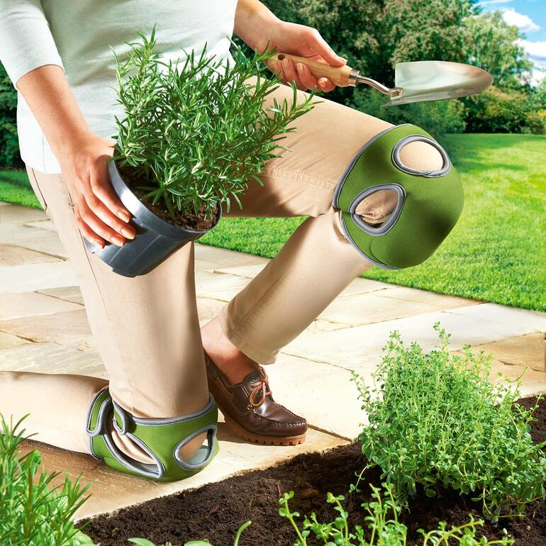 Frau in Garten mit Komfort-Knieschonern, beim Pflanzen von Kräutern.