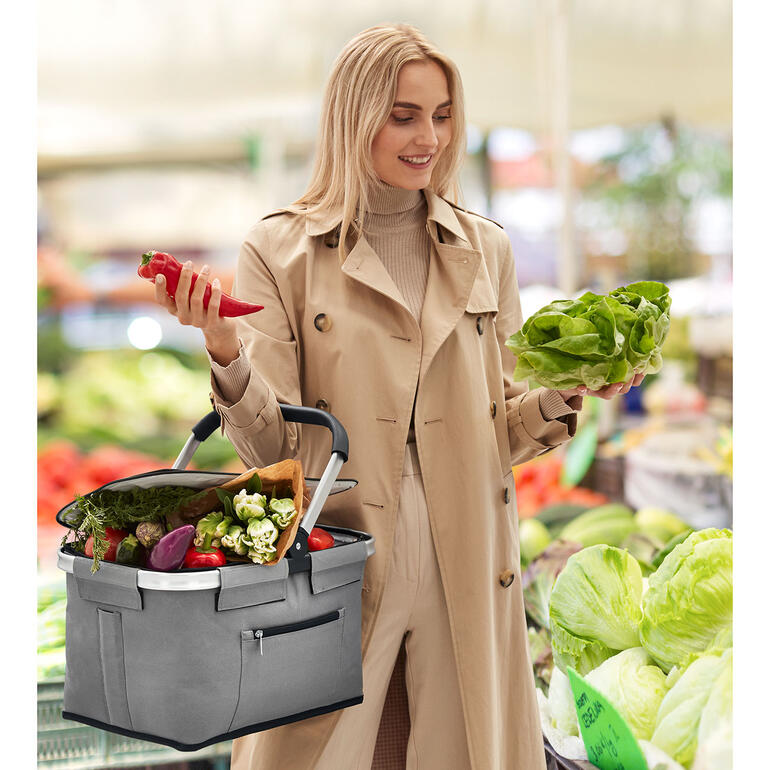 Frau mit faltbarem Iso-Einkaufskorb im Supermarkt.