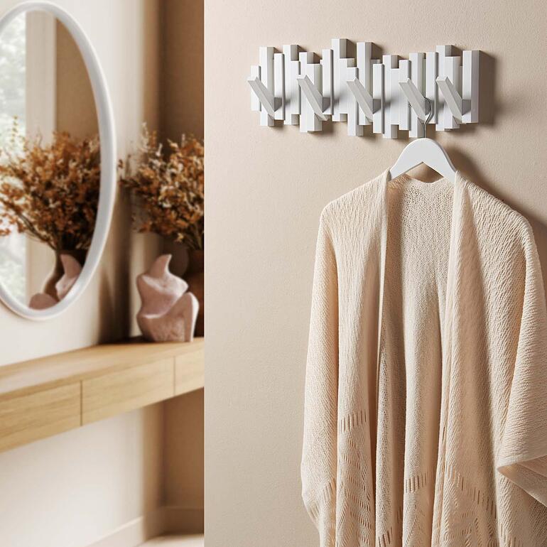 Wandgarderobe in Form einer Klaviatur, mit einem beigen Kimono daneben.