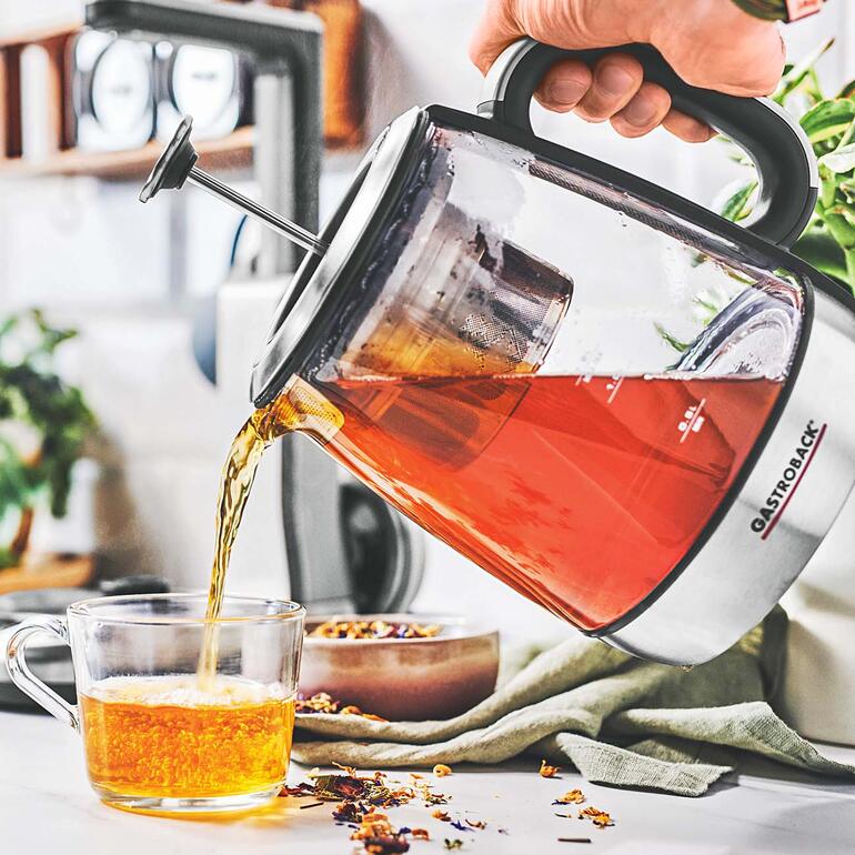 Bereitet Ihren Lieblingstee punktgenau nach Ihrem Geschmack. Person gießt frischen Tee aus einer Gastroback Teekanne in eine Tasse.