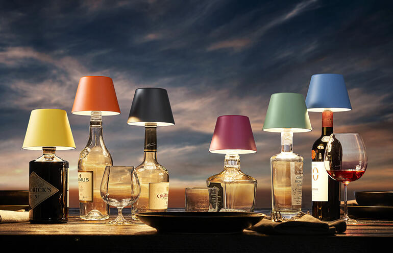 Sechs LED-Akku-Flaschenlichter in verschiedenen Farben auf einem Tisch.