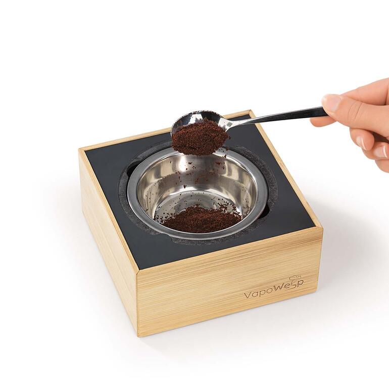Einfach in der Edelstahl-Brennschale 1 TL Kräutermischung mit 2 TL Kaffeepulver mischen, anzünden und die Box verschliessen. Räucherbox VapoWesp mit einer Hand, die Kaffeepulver einfüllt.