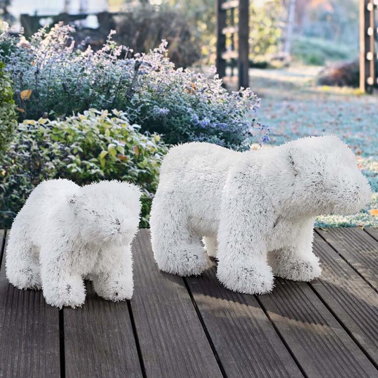 Zwei flauschige Eisbären aus künstlichem Material auf Holzdeck.