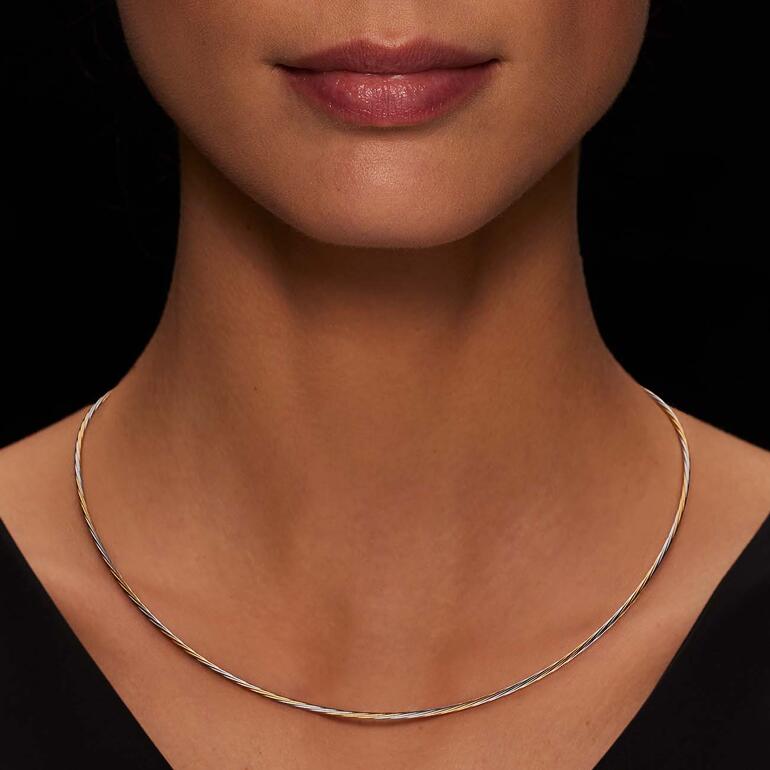 Frau trägt ein Bi-color Kabelcollier, sichtbar im Dekolleté.