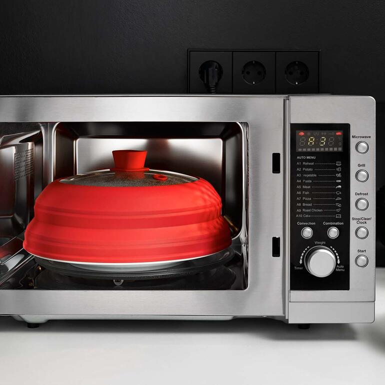 Auch perfekt als Spritzschutz in der Mikrowelle. Rote Universal-Abdeckung in Mikrowelle mit Timer