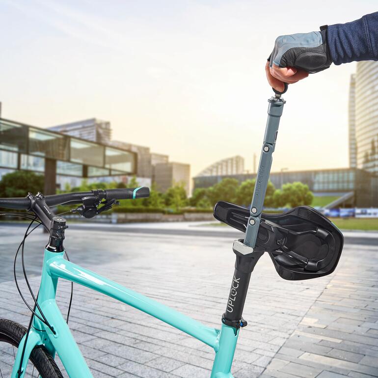 Person zieht UPLOCK®-Schloss vom Fahrrad ab