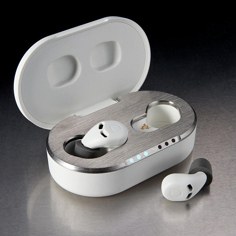 Bouchons d’oreille de sommeil QuietOn 3.1 Offene Ladebox mit QuietOn 3.1 Schlaf-Ohrstöpseln auf einem Tisch.