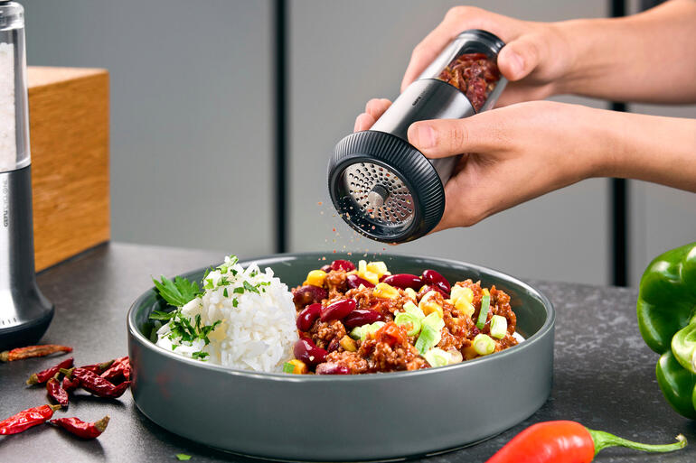 Chili-Schneider X-Plosion® Chili-Schneider X-Plosion® wird über einen Teller mit Reis und Gemüse gehalten