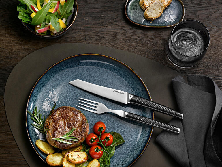 Steak-Besteck Prime Rib, 2er-Set auf einem modernen Teller mit Steak und Beilagen.