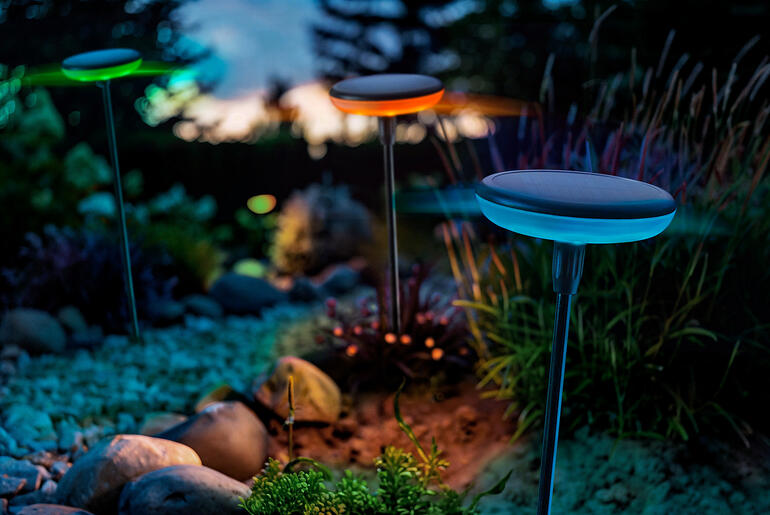Lampes solaires avec changement de couleurs, lot de 3 pièces Solarleuchten mit Farbwechsel in einem Garten bei Dämmerlicht.