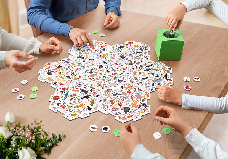 Gruppenspiel mit bunten Karten auf einem Tisch.