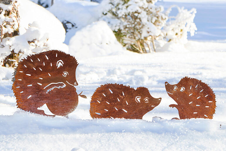 Drei Gartenstecker in Igel-Design, im Schnee, aus Metall.