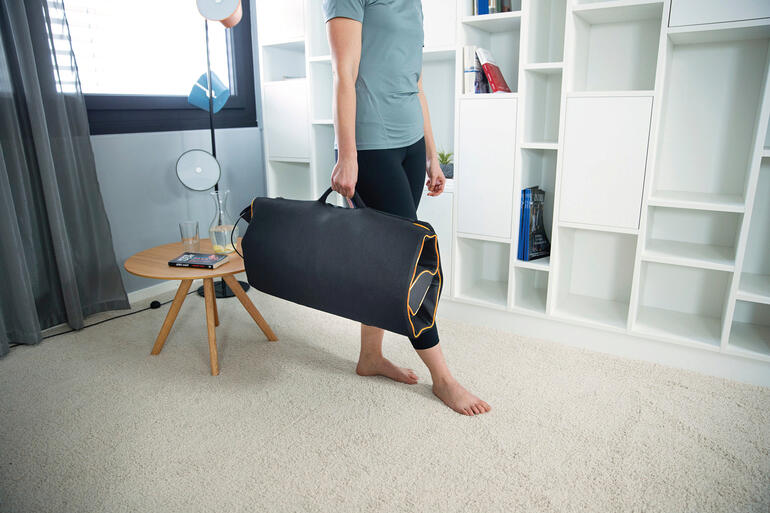 Mann trägt eine Dehn- und Massagematte in einer Tasche