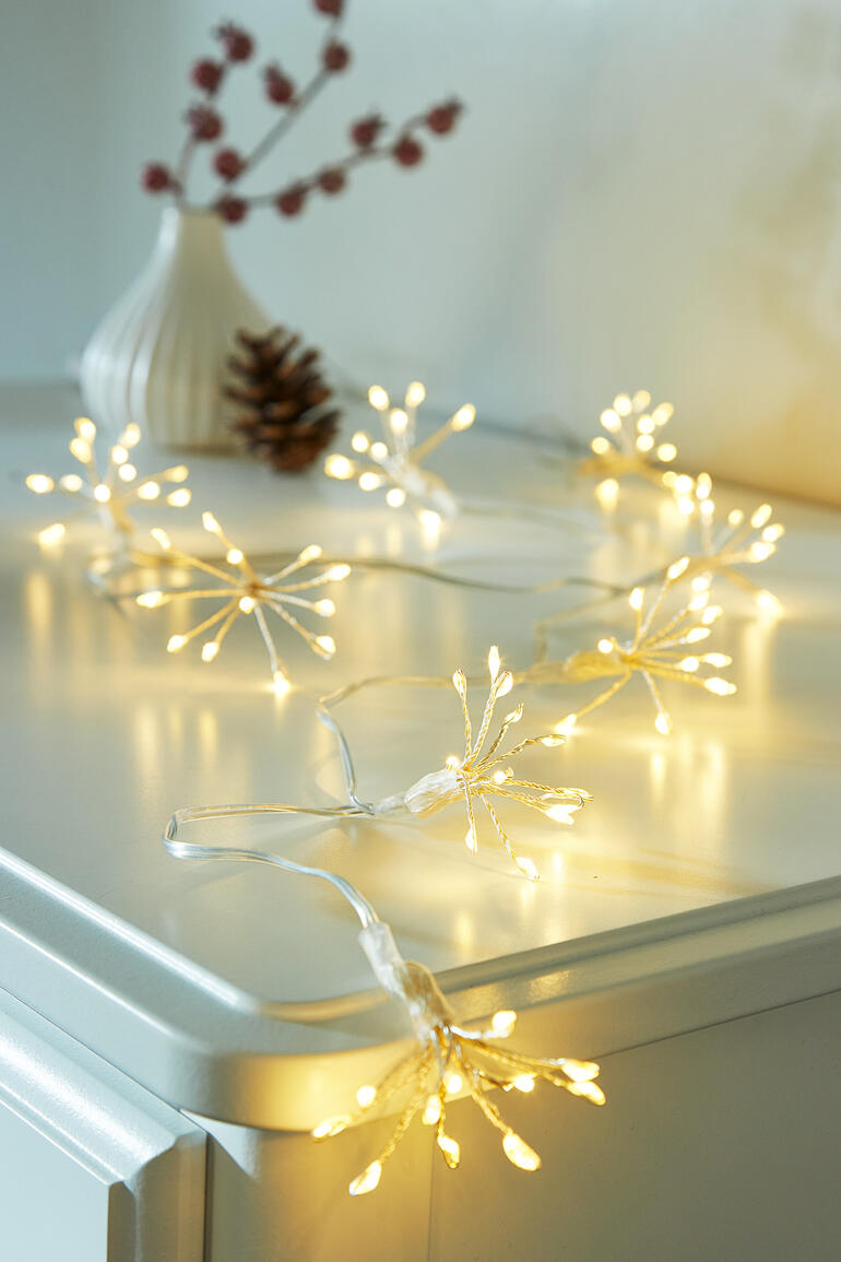 Lichterkette mit warmen, goldenen Lichtern auf einem Tisch dekoriert.