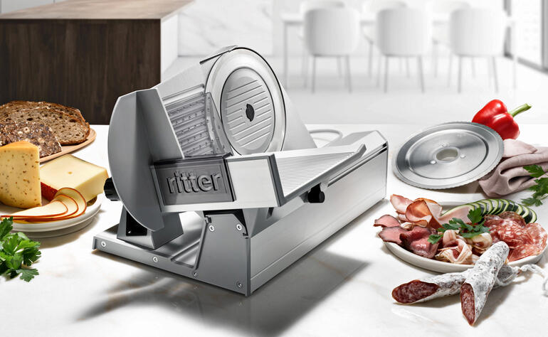 Feinschneider Tondo 13 auf einer Küchenarbeitsplatte mit Fleisch, Käse und Gemüse.