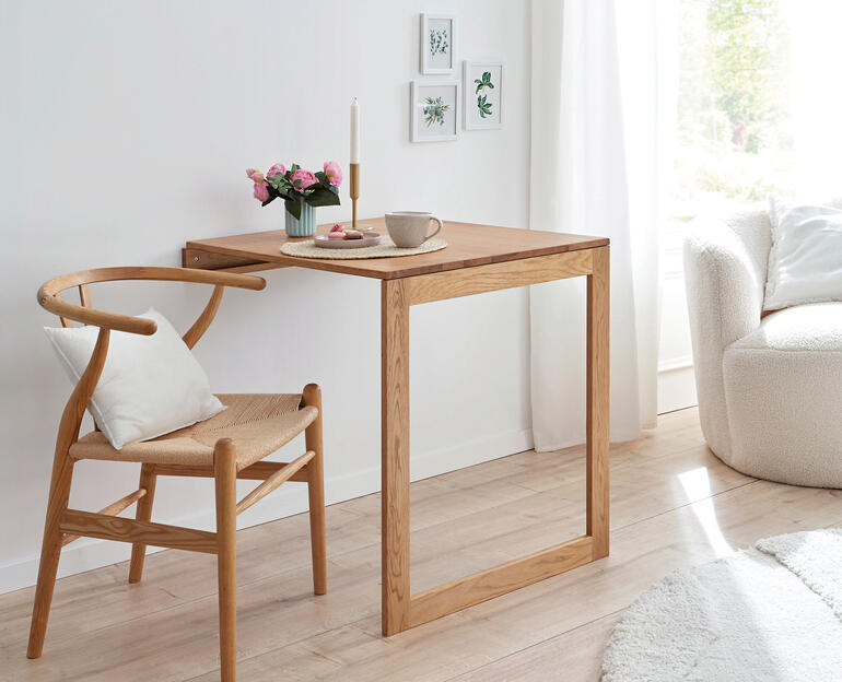 Wand-Klapptisch aus Holz mit Kaffee und Blumen auf der Oberfläche.