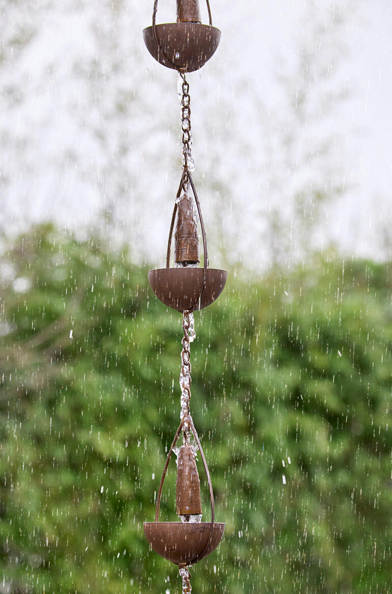 Das Regenwasser fliesst sanft über die Kette nach unten und bereichert Ihren Garten um einen optischen und akustischen Reiz. Detailansicht einer 3-in-1-Regenkette mit Wasser, das von den Bechern fließt.