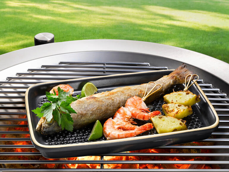 Dank 3 mm hohen Keramiknoppen versinkt Ihr Grillgut nicht ungesund in austretendem Fett. Fisch und Garnelen auf einer Grillplatte im Freien