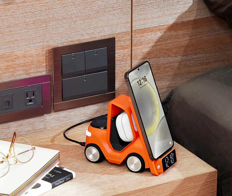 Oranger Qi-Lade-Stapler mit aufgeladenem Smartphone und digitaler Uhranzeige.