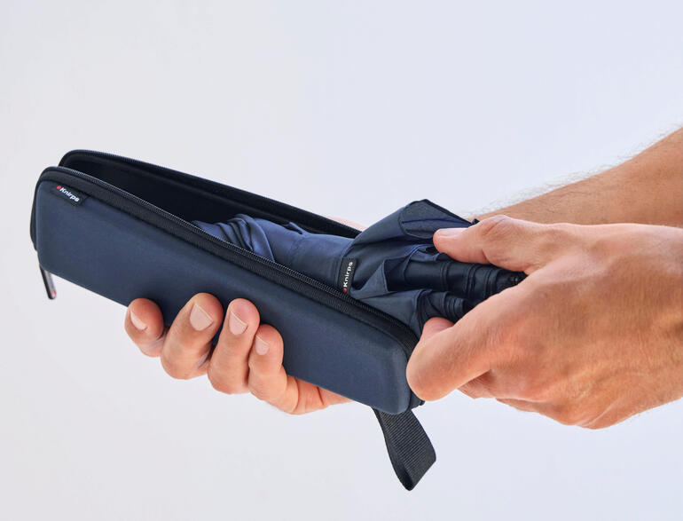 Marine Jemand hält einen Taschenschirm und steckt ihn in ein trockenes Etui.
