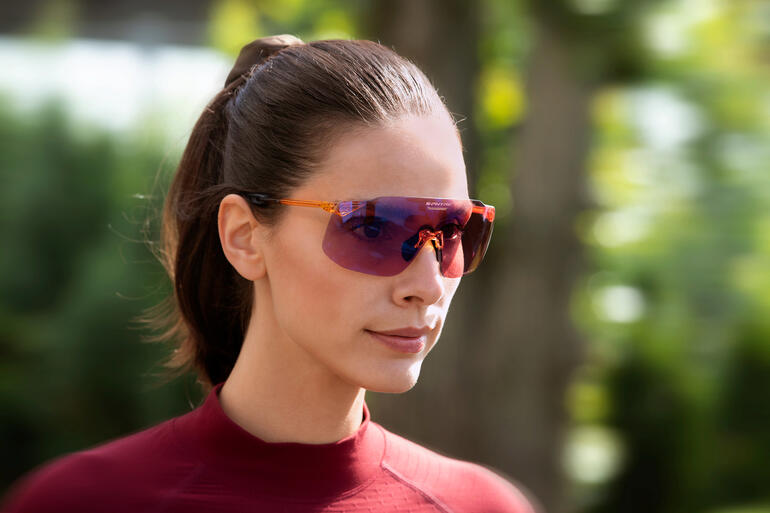 Frau in Sportbekleidung trägt eine Sonnenbrille.
