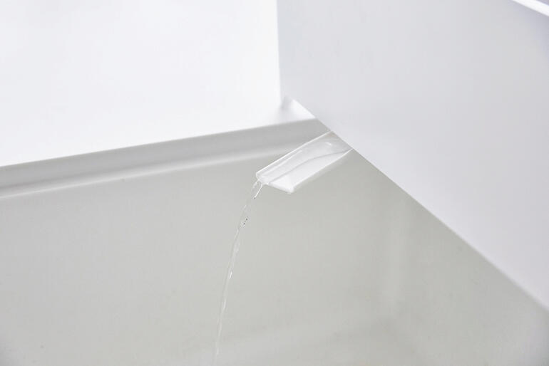 Weiss Nahaufnahme des Abtropfkorbs mit Wasserabfluss.