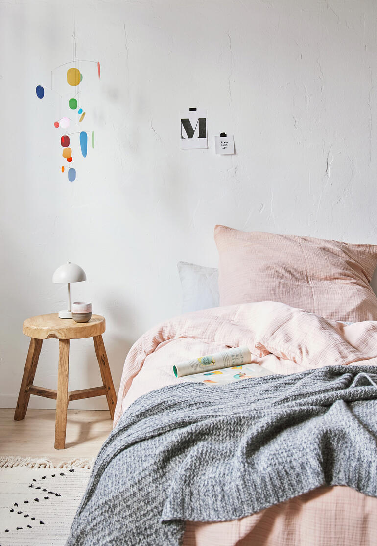 Zukunfts-Mobile hängt über einem Bett in einem Schlafzimmer