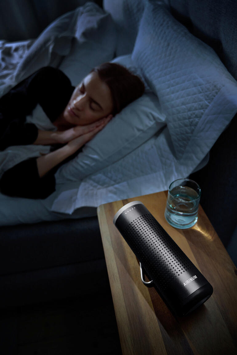 Mobiler 2-in-1 Luftreiniger auf einem Nachttisch neben schlafender Person