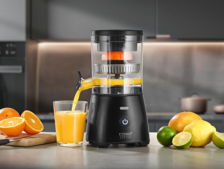 Vollautomatische Zitruspresse in der Küche, Orange wird ausgepresst.