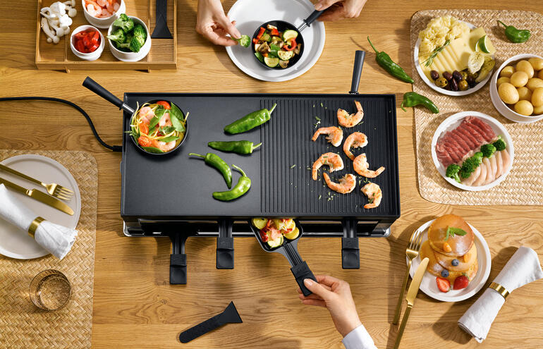 Solis Raclette- und Fun-Cooking 5-in-1-Gerät wird mit Meeresfrüchten serviert.