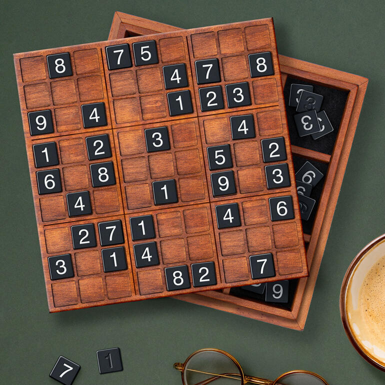 Aus Holz gefertigtes Sudoku Deluxe mit schwarzen Zahlen auf einem grünen Tisch