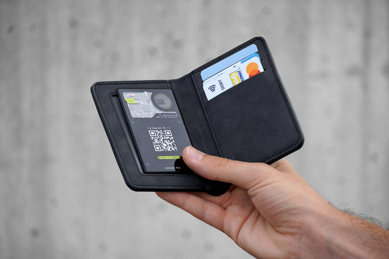 Hand hält AirCard Pro Apple in schwarzem Etui