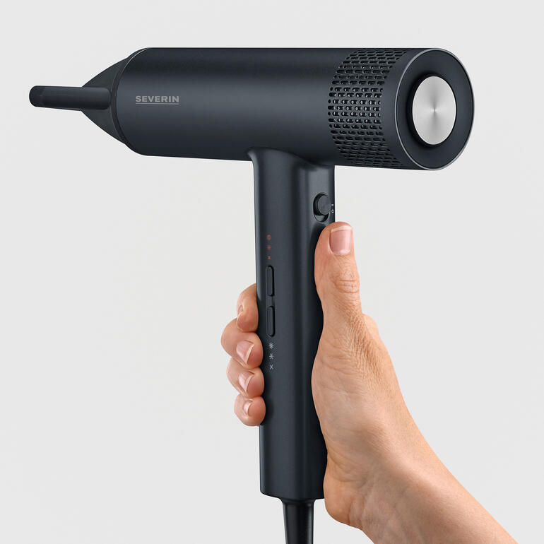 Profi-Haartrockner mit Magnetaufsätzen Nahaufnahme eines schwarzen Haartrockners mit Bedienelementen in der Hand.