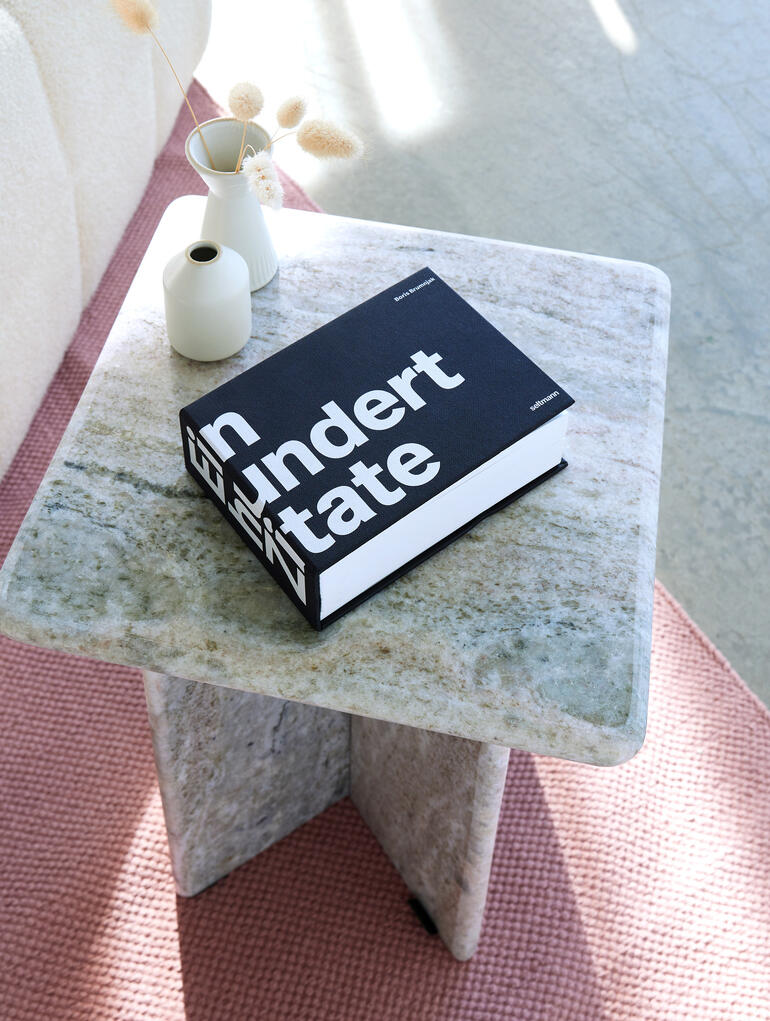 Buch mit dem Titel 'Hundert Zitate' auf einem Tisch.