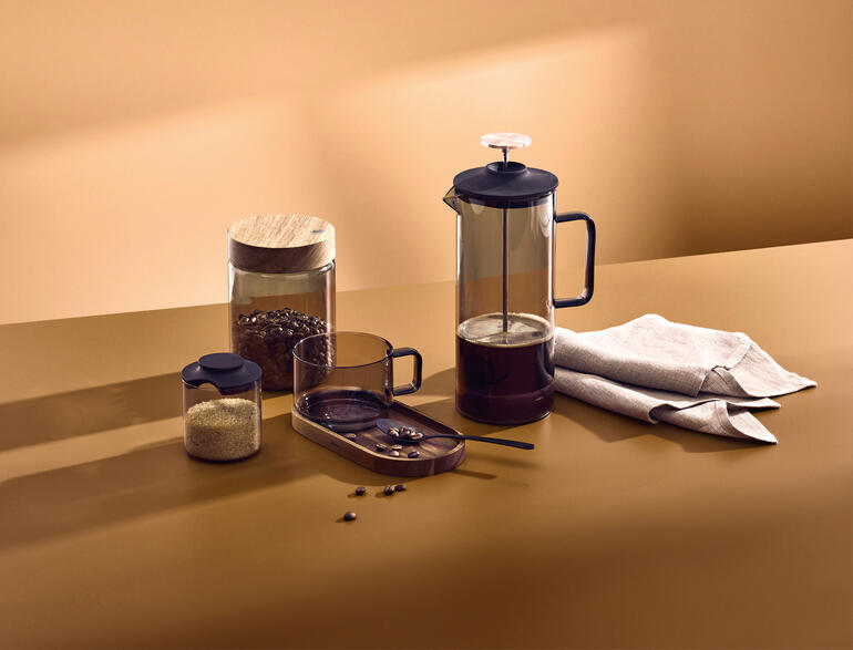 Mundgeblasene French-Press mit 600 ml, Kaffeebohnen und Gläsern auf einem Tisch.