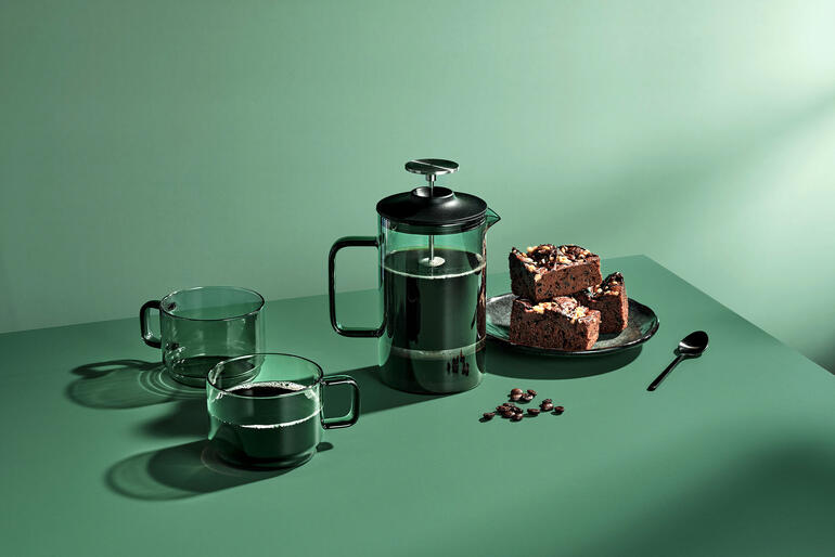 Mundgeblasene French-Press mit 600 ml und Schokoladenkeksen, Gläsern auf grünem Tisch.